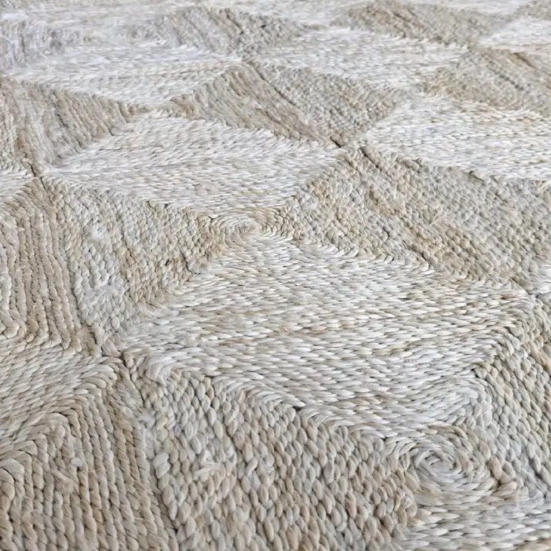 A close-up of a natural jute rug with a diamond pattern